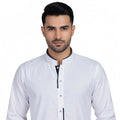 Man wearing a white shirt with black trim on a white background