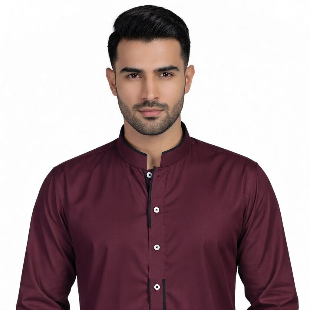 Man wearing a maroon shirt with a plain background