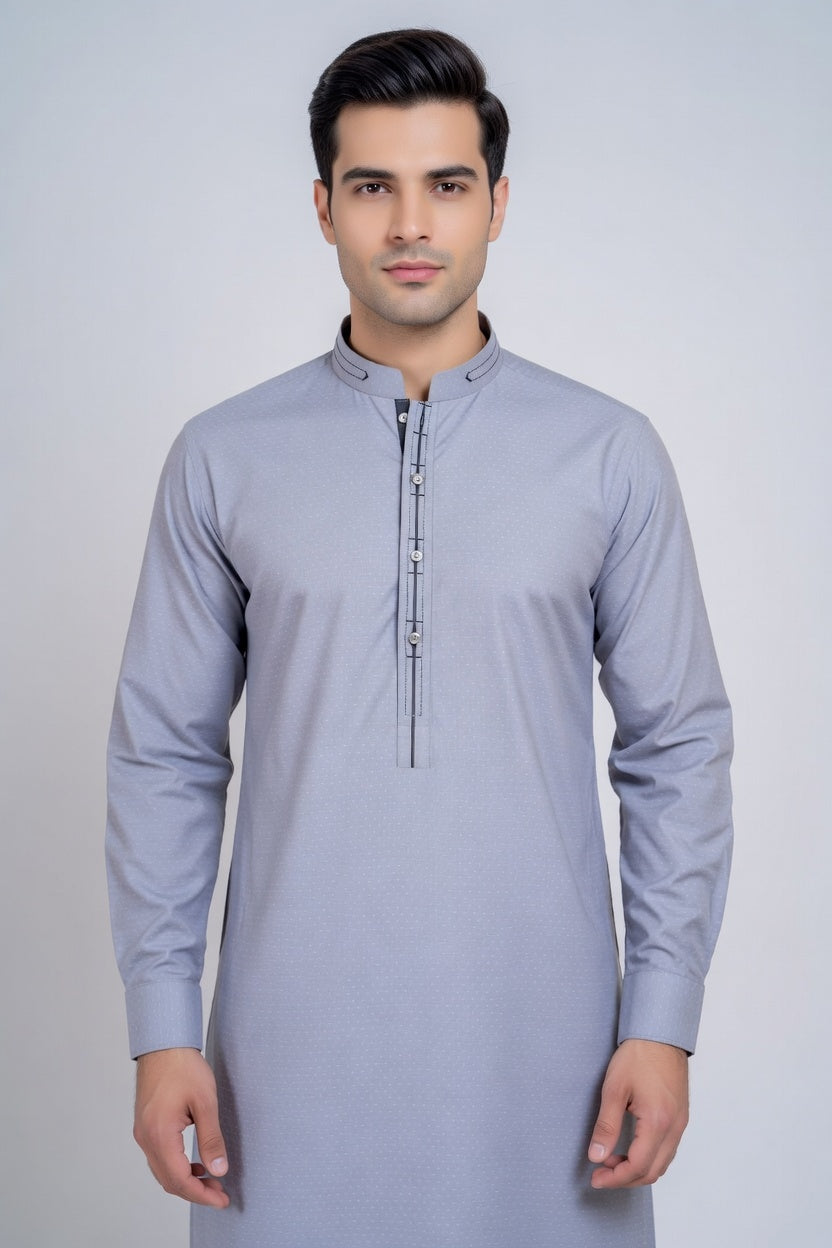 Man wearing a light gray kurta against a plain background