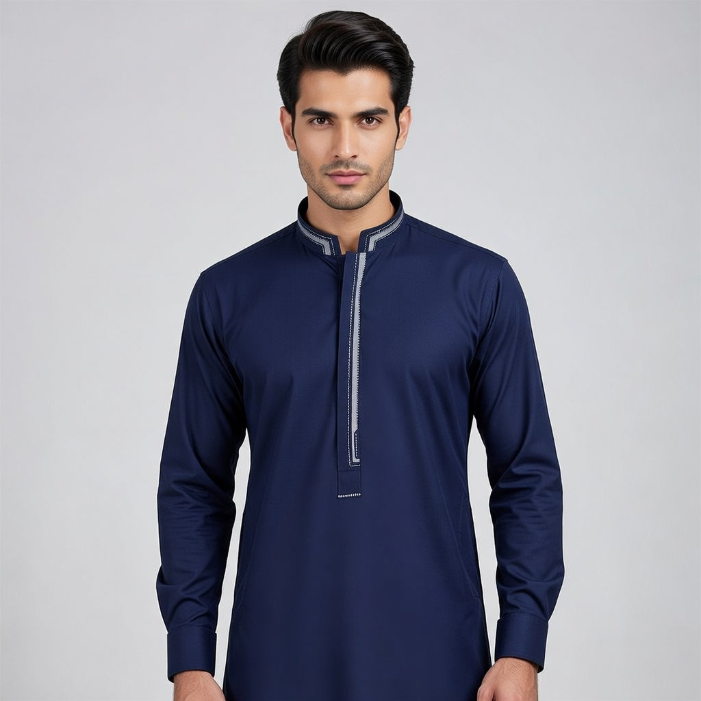 Man wearing a navy blue long-sleeve shirt with a zipper on a gray background