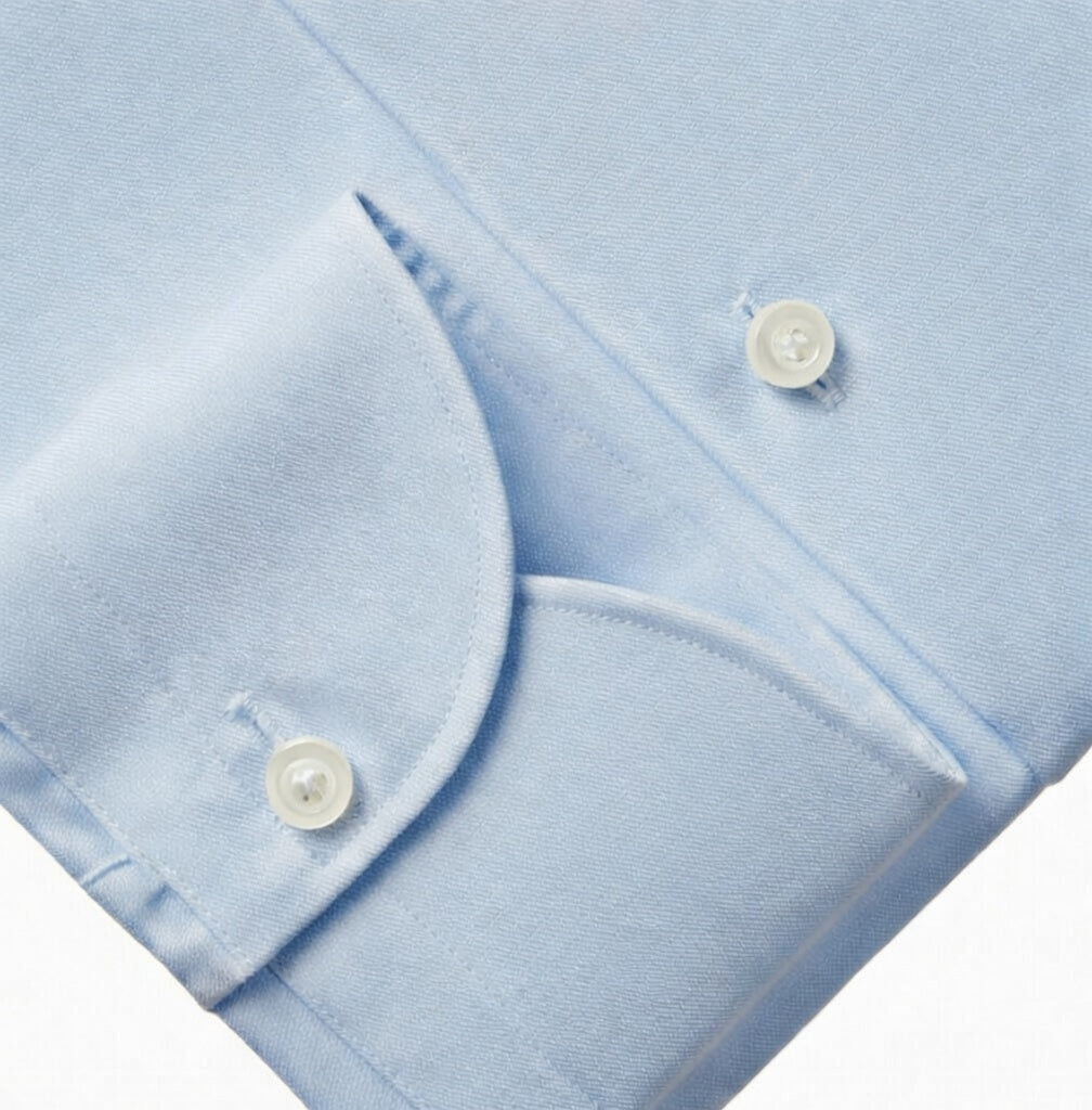 Close-up of a light blue shirt with button details on a white background