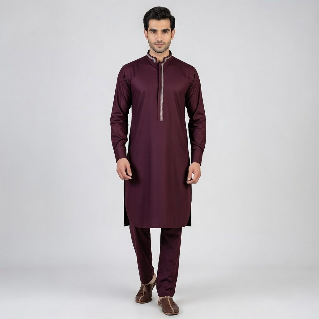 Man wearing a maroon kurta with pants on a white background