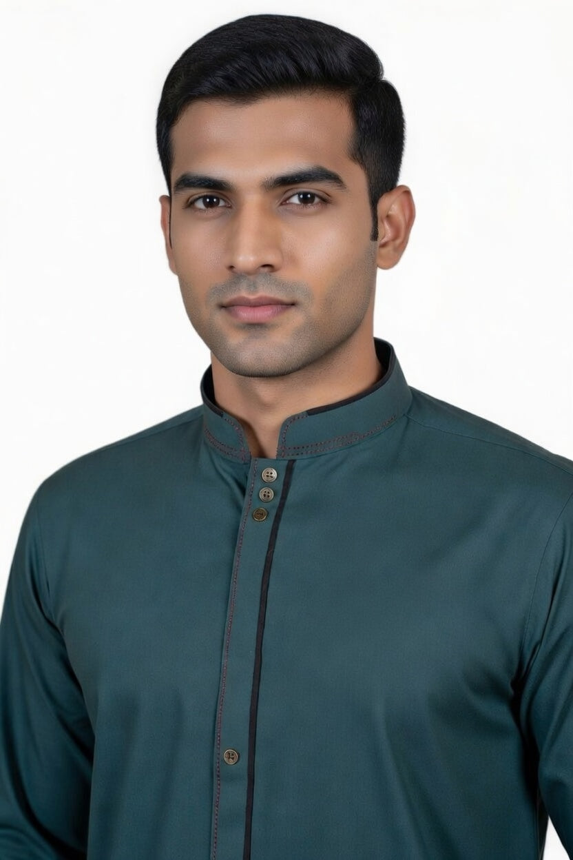 Man wearing a teal kurta with a plain background