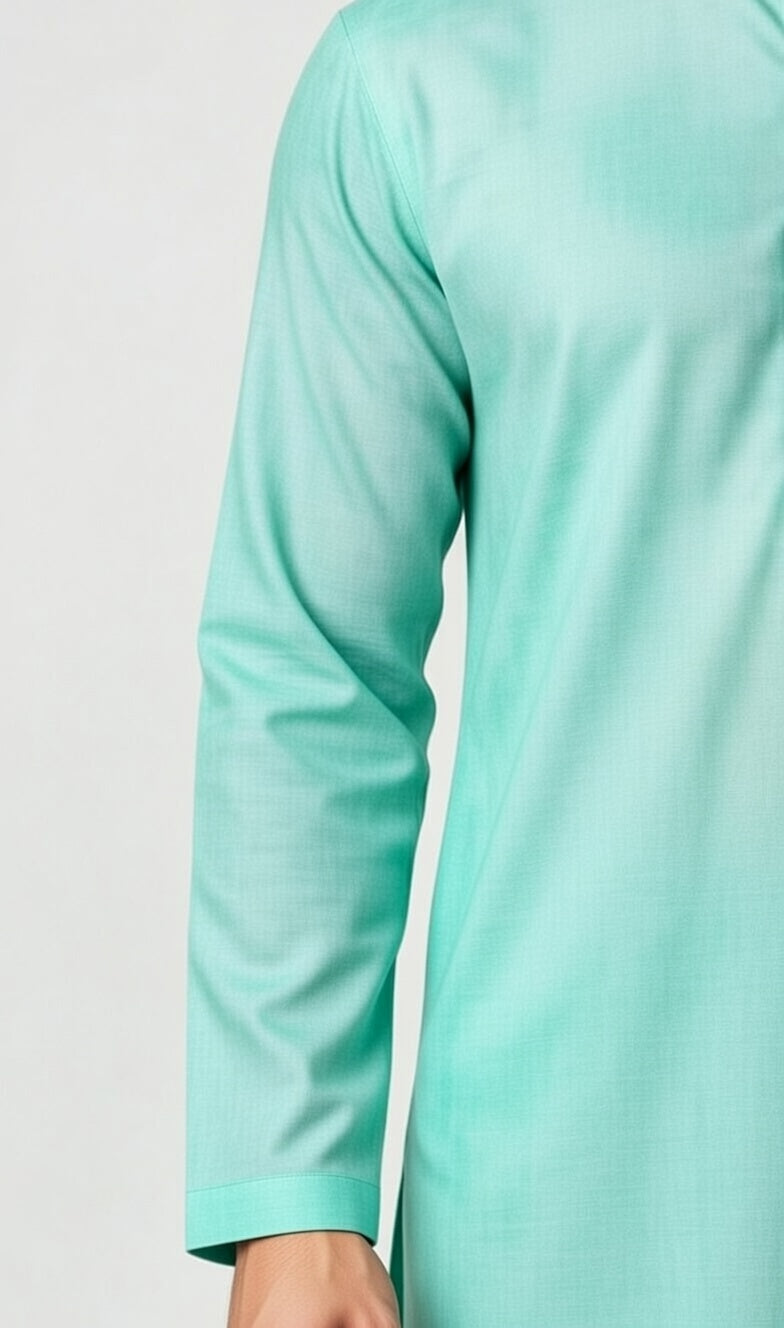 Close-up of a light green long-sleeve top on a plain background