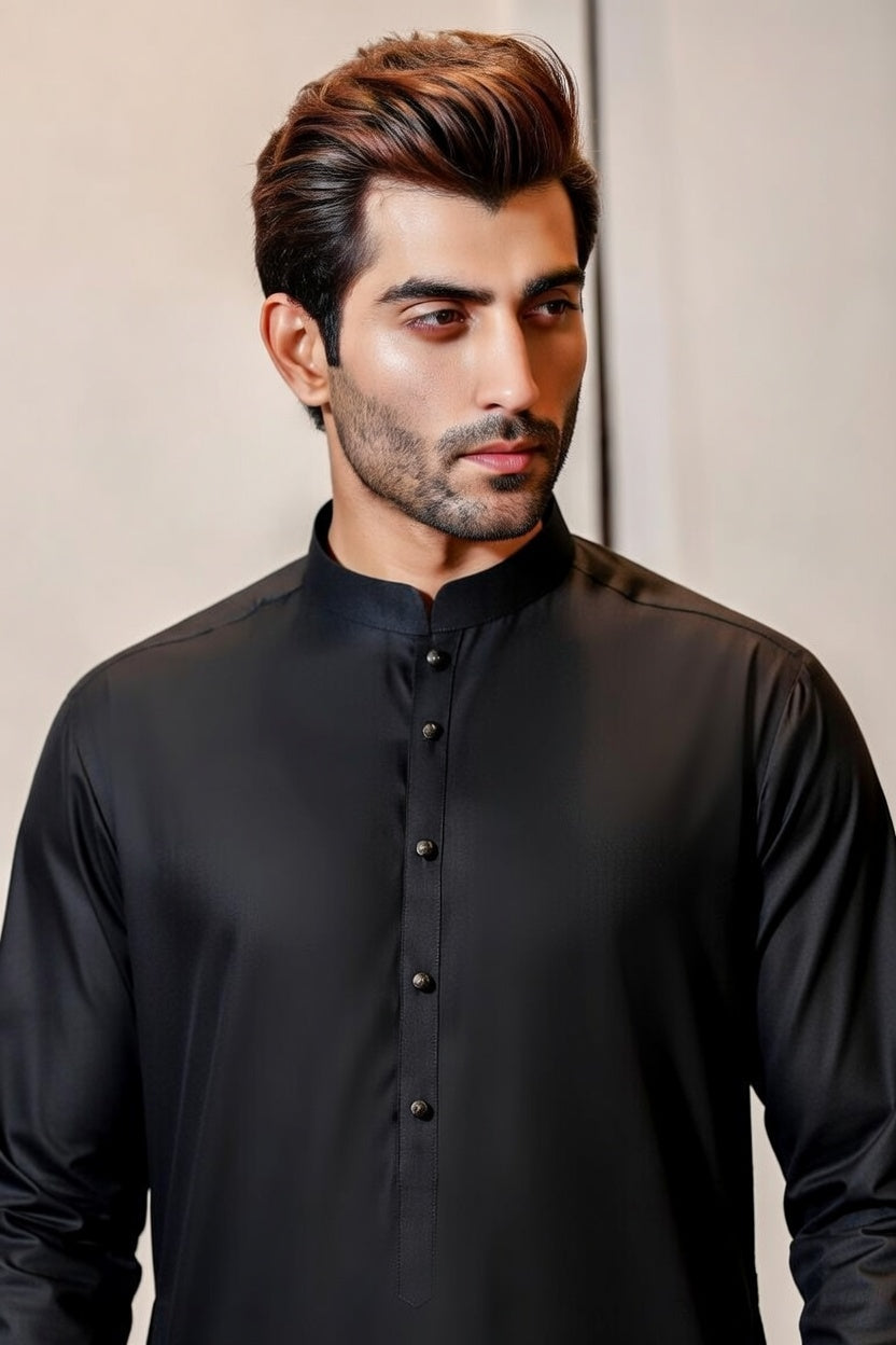 Man wearing a black traditional kurta against a neutral background