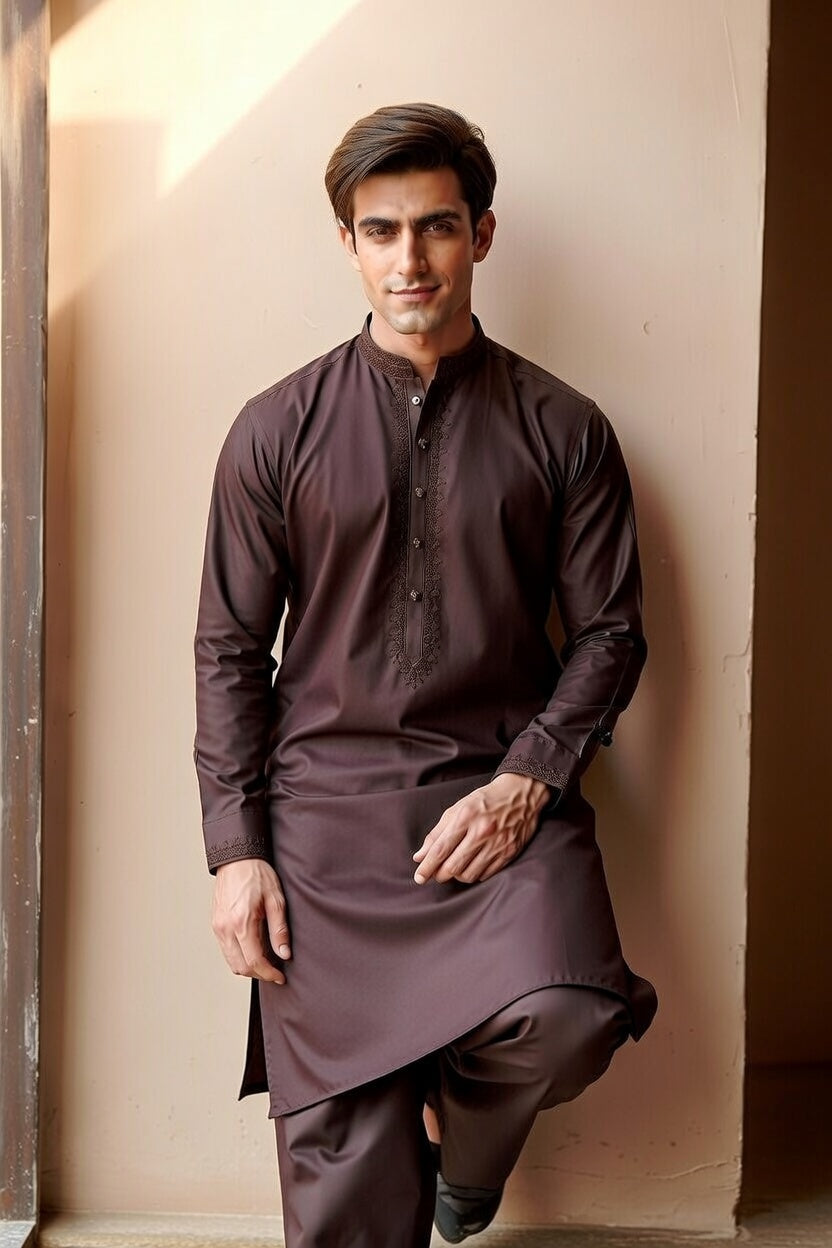 Man wearing a brown kurta against a beige wall