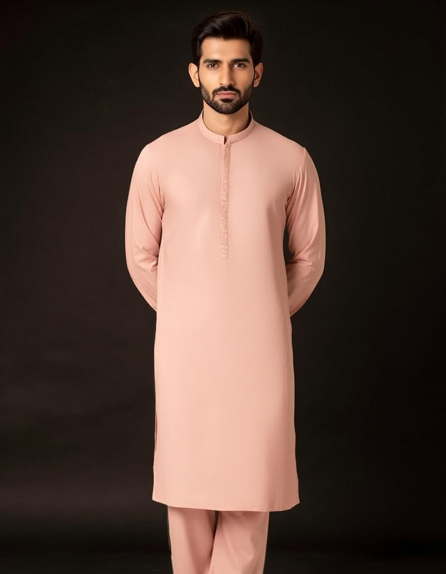Man wearing a peach kurta with a black background