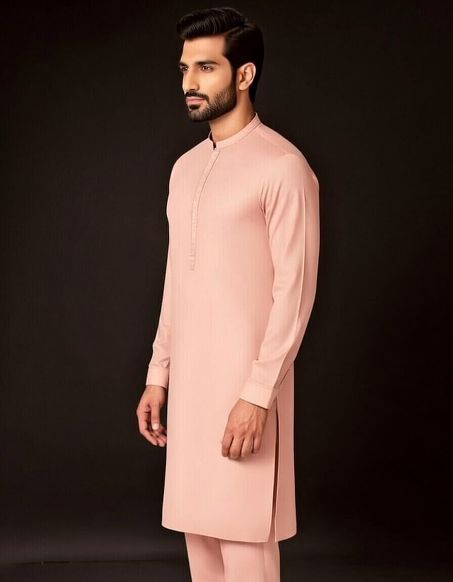 Man wearing a light pink kurta against a black background