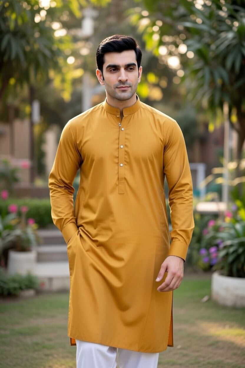 Man wearing a mustard yellow kurta with white pants in an outdoor setting