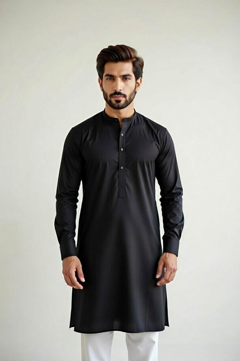 Man wearing a black kurta with white pants on a plain background