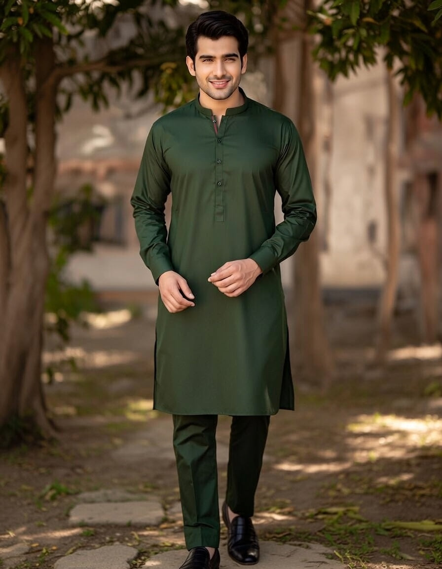 Man wearing a green kurta with black pants standing outdoors.