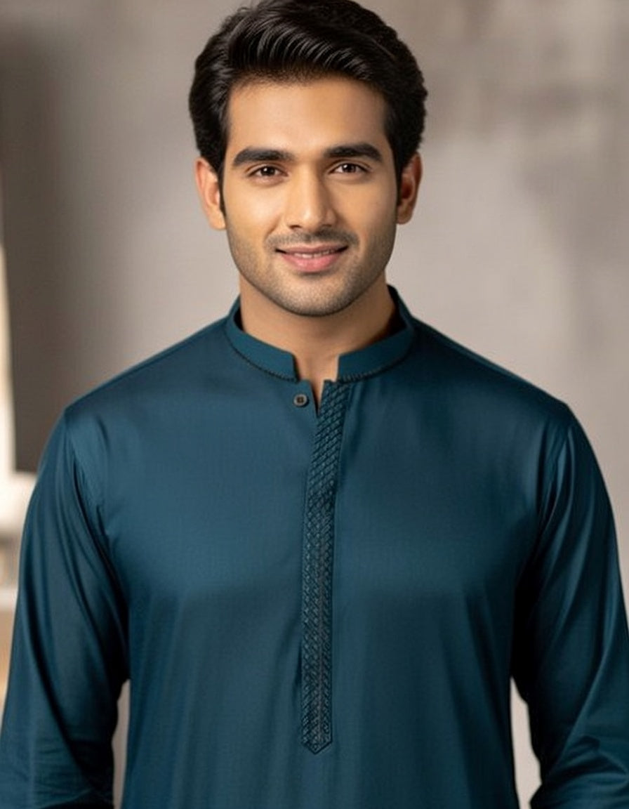 Man wearing a teal kurta with intricate detailing on a neutral background