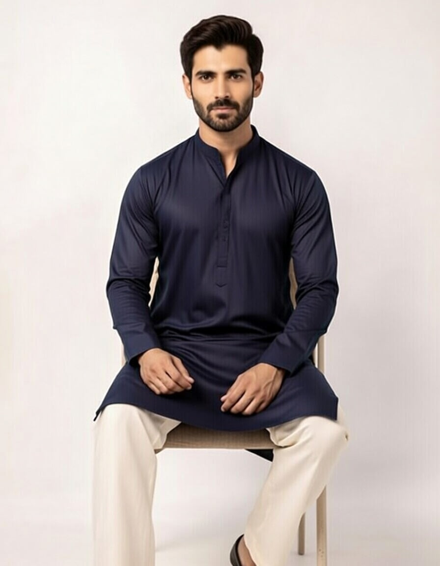 Man wearing a navy kurta with white pants on a light background