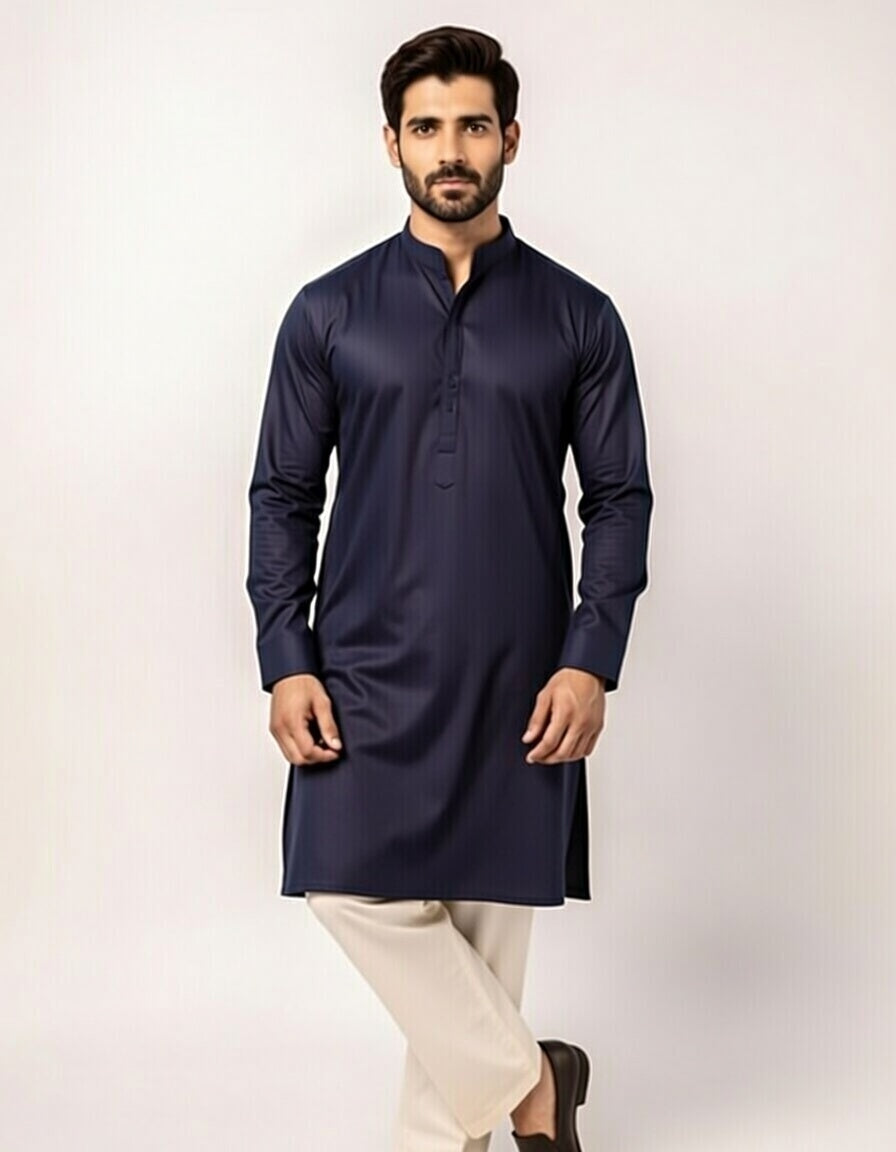 Man wearing a navy kurta with white pants on a light background