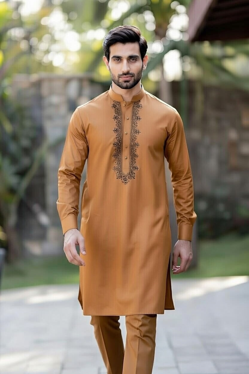 Man wearing a mustard yellow kurta with intricate embroidery outdoors.