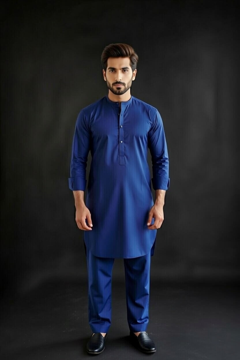 Man wearing a blue kurta with black shoes on a dark background